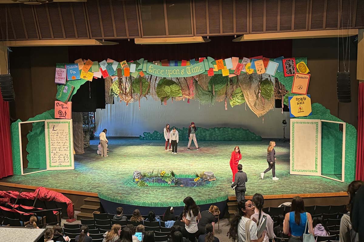 A wide view of Santa Catalina School's "Shrek The Musical" set. Students are seen on stage and in the audience.